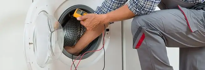 Dryer repair technician inspecting and repairing a clothes dryer in Mesa, AZ