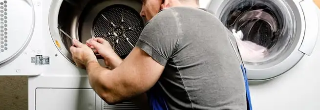 Dryer repair technician fixing a clothes dryer drum in Mesa, AZ