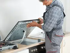 Appliance repair technician installing a built-in cooktop in Mesa, AZ