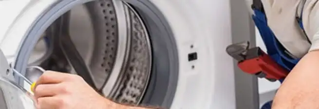 Appliance technician repairing a clothes dryer drum and internal parts in Mesa, AZ