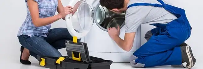 Washer repair technician inspecting a front-load washing machine with tools in Mesa, AZ