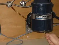 Garbage disposal repair technician tightening the mounting ring under a sink in Mesa, AZ