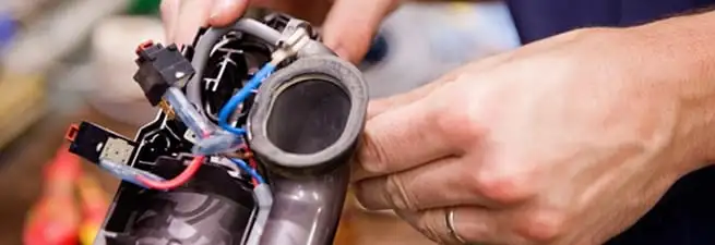 Vacuum repair technician reconnecting wiring and components in Mesa, AZ