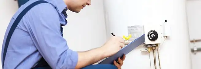 Water heater repair technician inspecting the unit and recording service notes in Mesa, AZ