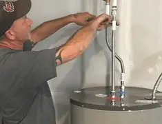 Water heater repair technician tightening supply line connections in Mesa, AZ
