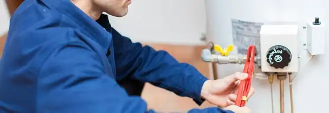 Water heater repair technician adjusting the temperature control and gas valve in Mesa, AZ